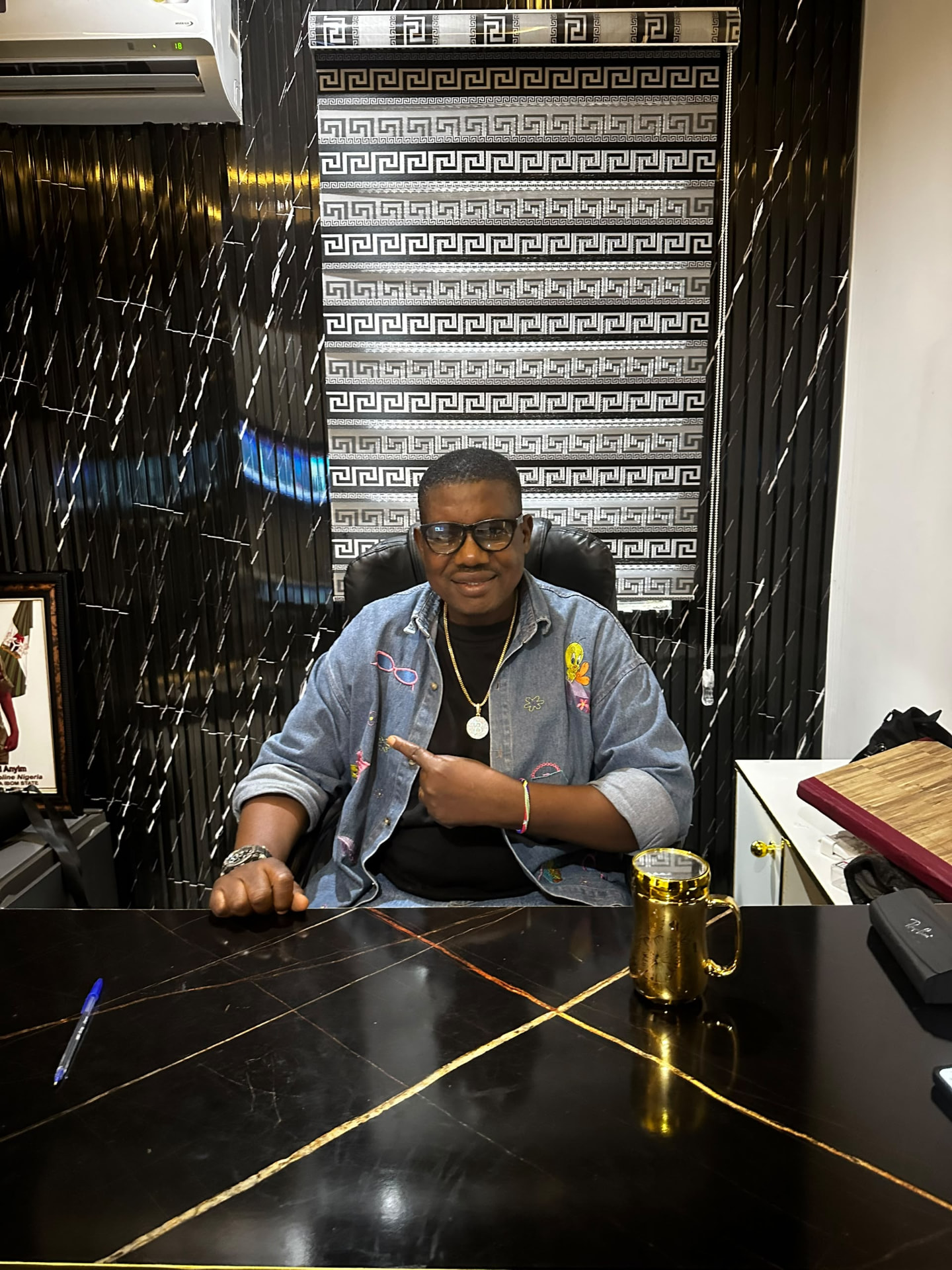Dr. Ferdinand Anylm, founder and CEO of Lass B Luxury Butik, at his desk in the boutique